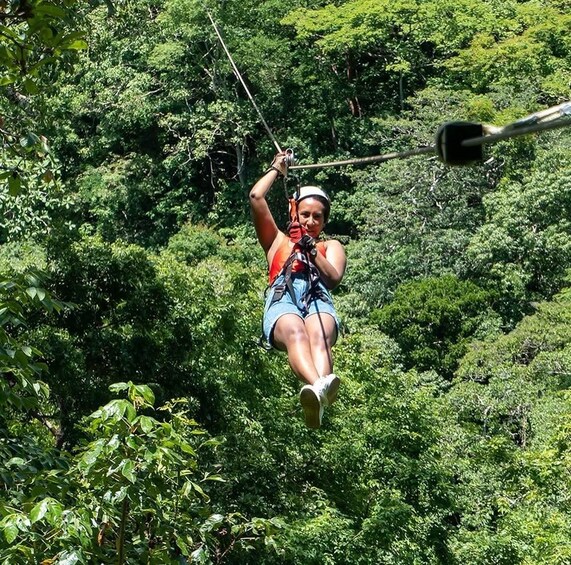 A person zip-lining through a dense forest. 5