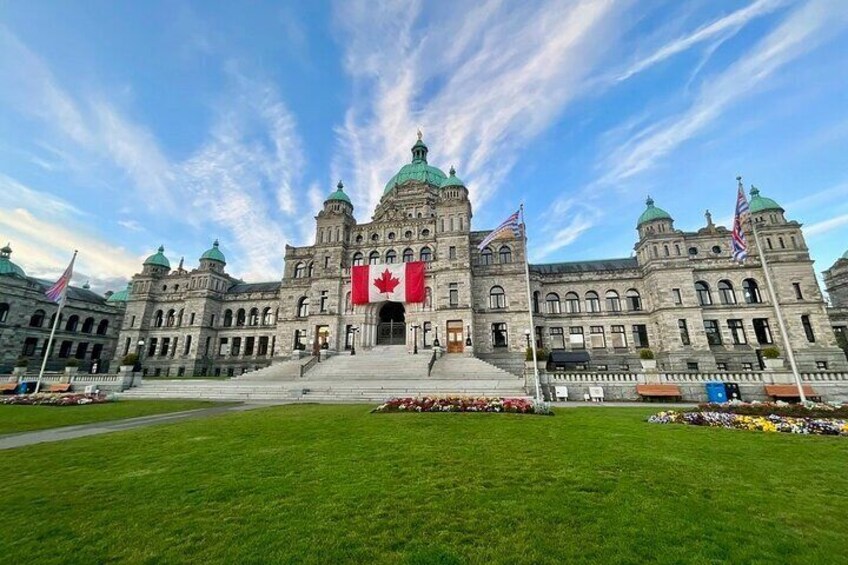 A large, historic building with a central dome and multiple flags, including a prominent red Canadian flag. 4