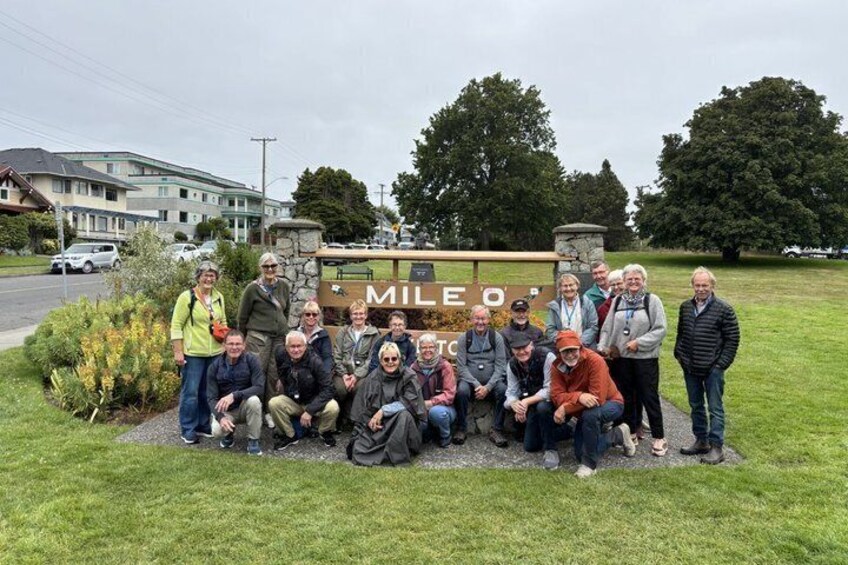A group of people posing in front of a sign with the word 'MILEO' on it. 2