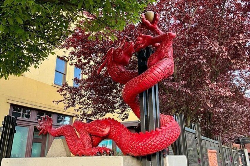 A large red dragon sculpture in an urban setting. 3