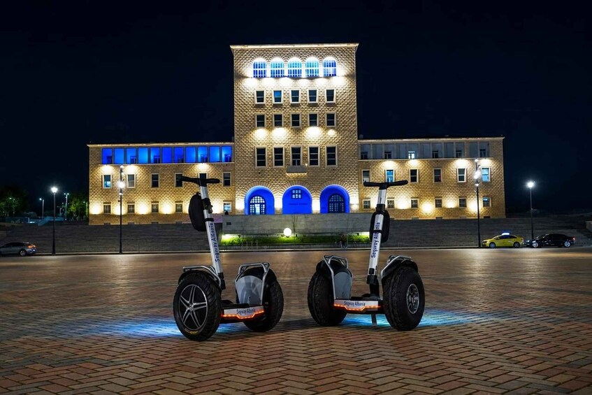 Two Segway scooters parked in front of a lit-up building at night. 5