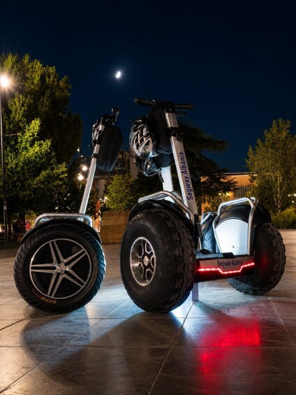 A Segway Albania electric scooter parked on a tiled surface at night. 2