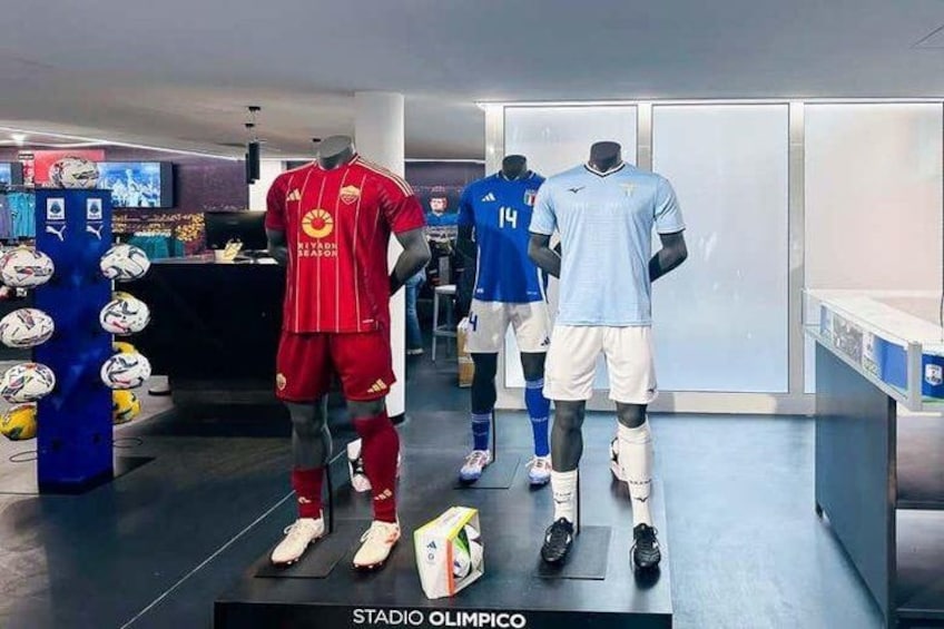 Mannequins in sports attire, a soccer ball, and a display of soccer shoes in a retail setting. 1