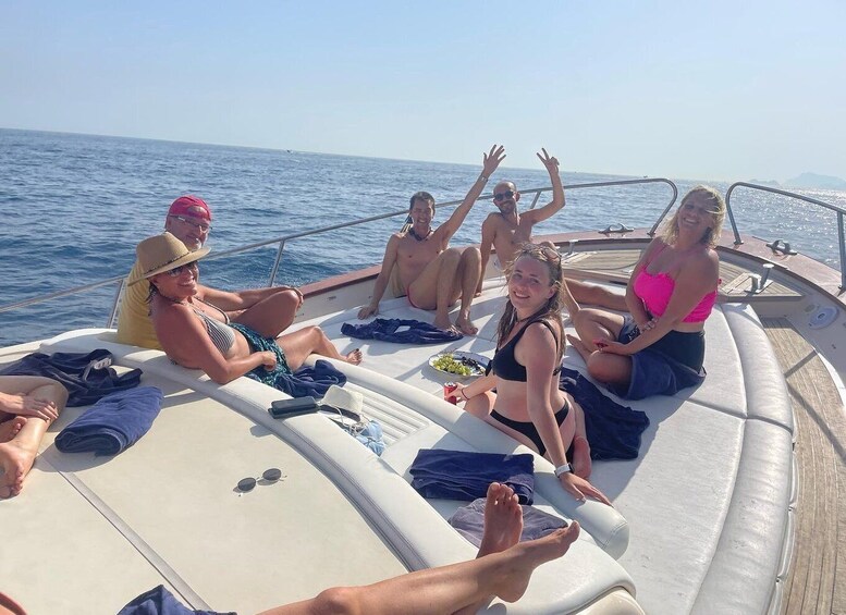 A group of people on a boat with the sea in the background. 1