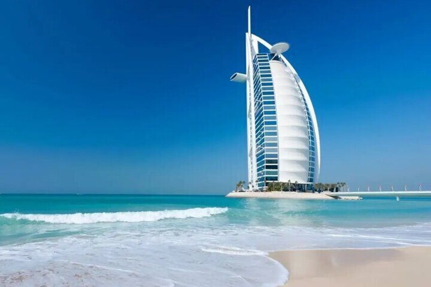 A coastal scene with a distinctive sail-shaped building near the shore. 5