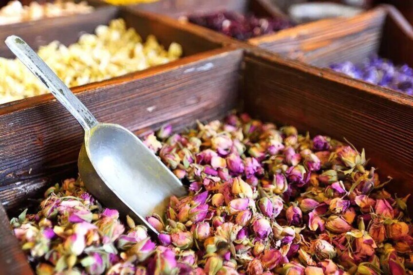 Wooden containers filled with dried flowers and a metal spoon. 2