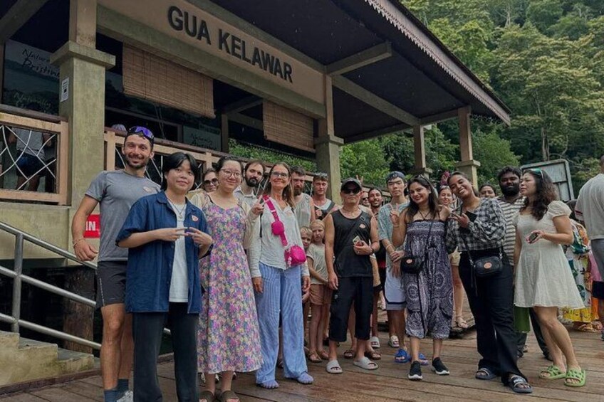 A group of people standing in front of a building labeled 'GUA KELAWAR.' 3