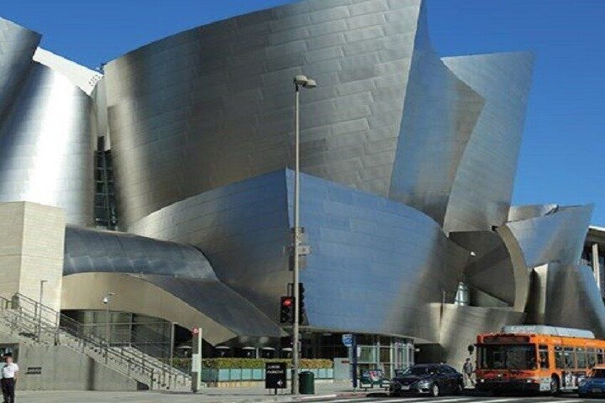 Een modern architectonisch gebouw met gebogen metalen oppervlakken en een trap naar de ingang. 5