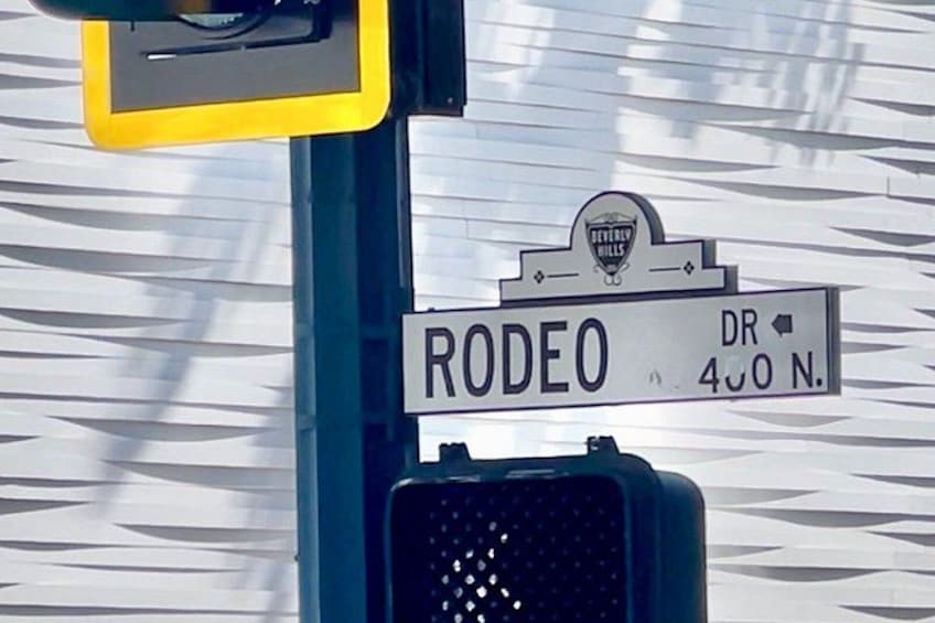 A street sign for Rodeo Drive with a traffic light below it. 2