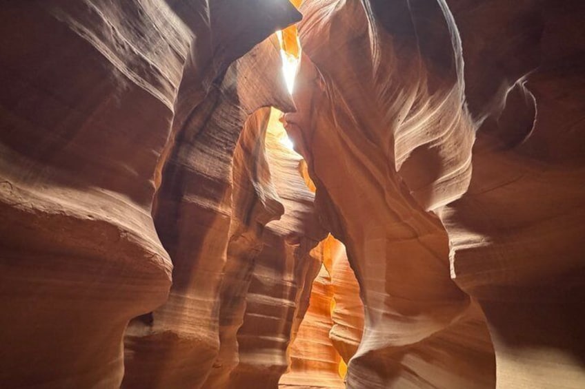 A canyon with layered rock formations and sunlight filtering through. 5