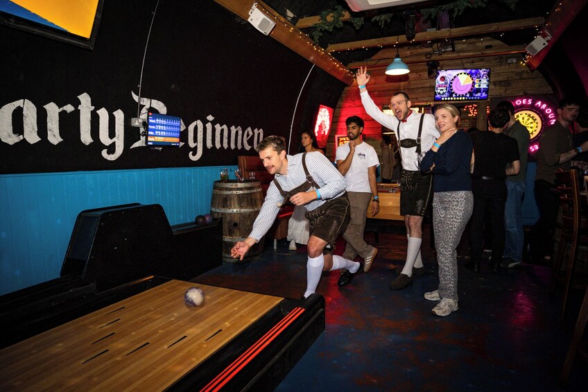 A billiards table in a bar with people around. 2