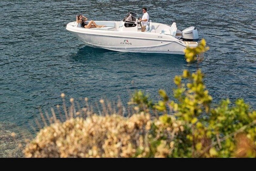 A white motorboat with people on board, floating on calm water. 4