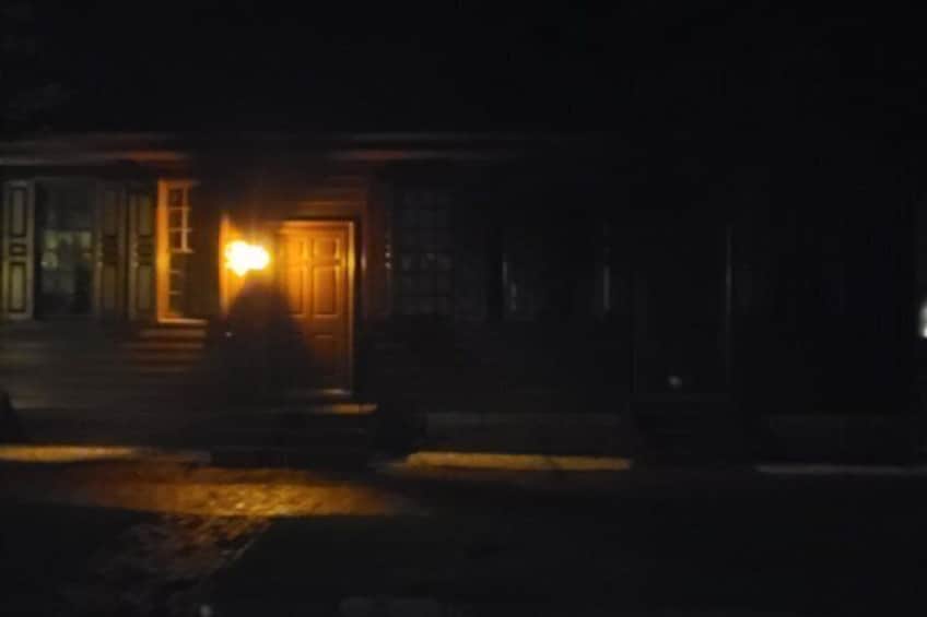 A house with a lit front door at night. 3