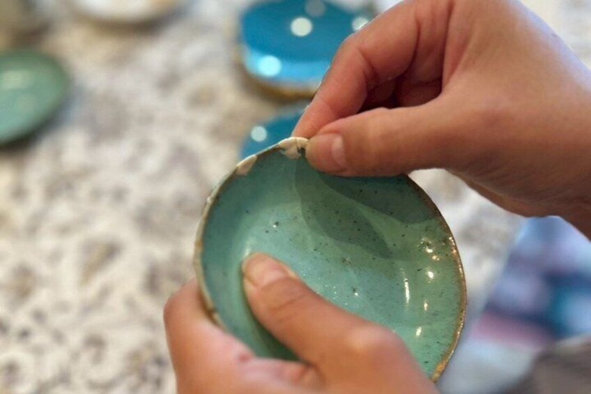 A person holding a green ceramic plate. 4