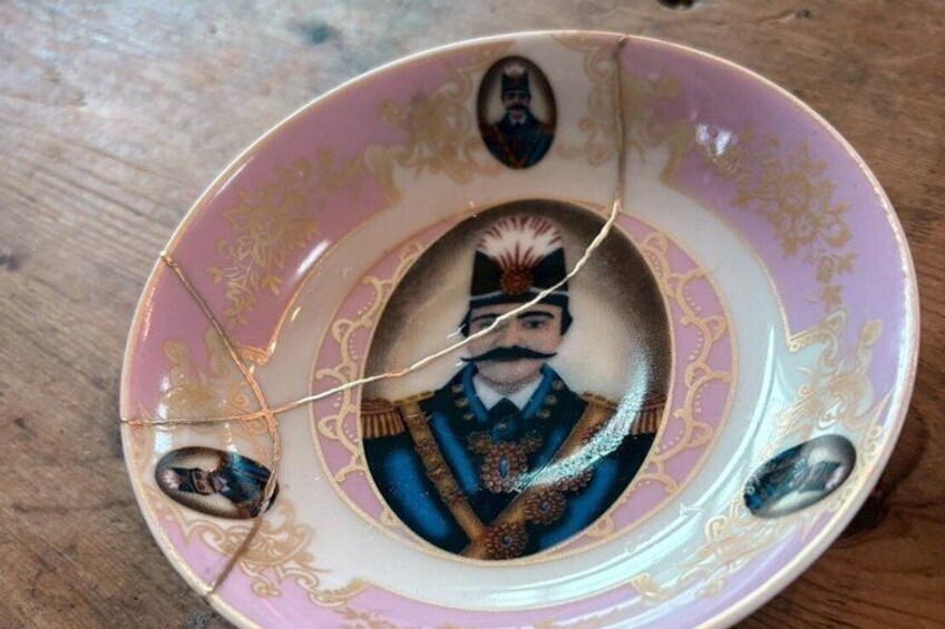 A decorative plate with a central portrait and ornate patterns. 2