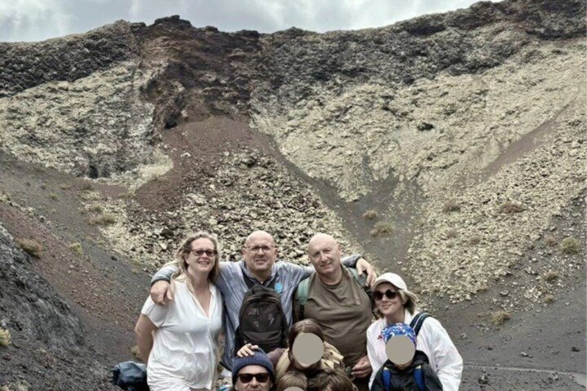 A group of people standing on a rocky terrain with a mountainous background. 5