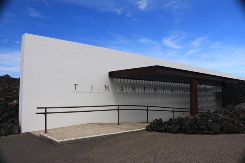 A modern building with a white facade and the name 'TIMANN' prominently displayed. 2