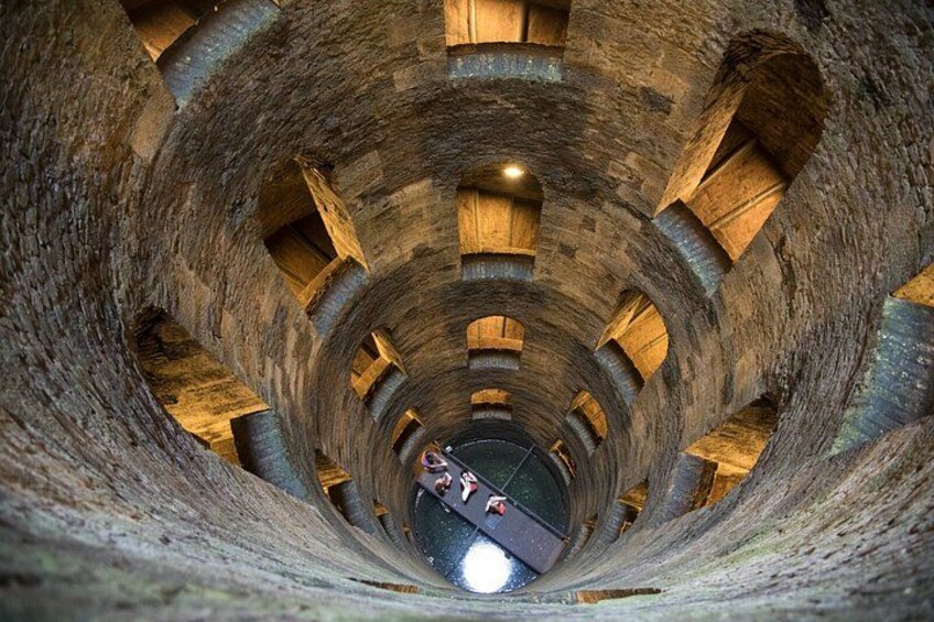A cylindrical stone structure with arched openings and a central light source. 3
