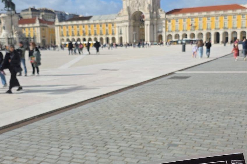 A paved square with a yellow building in the background. 4