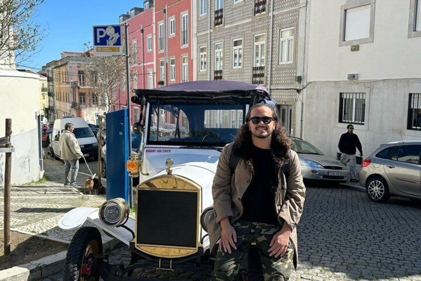 A vintage car parked on a cobblestone street with buildings in the background. 4