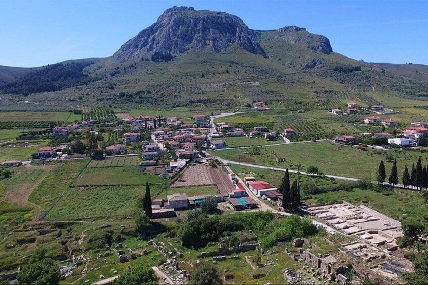 A rural town with houses, fields, and a prominent mountain in the background. 3