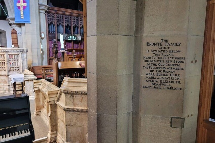 A church interior with a tombstone labeled 'The Bronte Family Vault' and a cross. 2