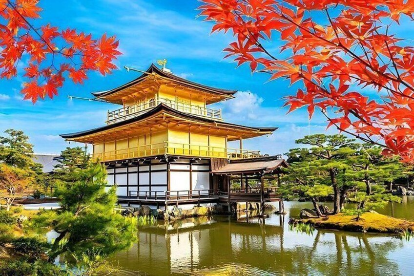 A traditional Japanese building with a golden roof, surrounded by a calm pond and autumn foliage. 1