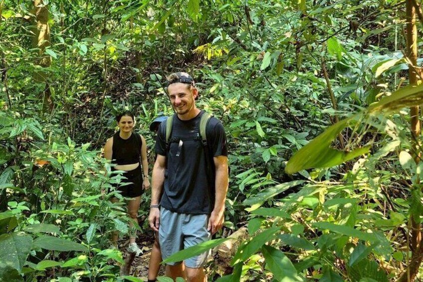 Two people hiking through a dense forest with a backpack on one individual. 4