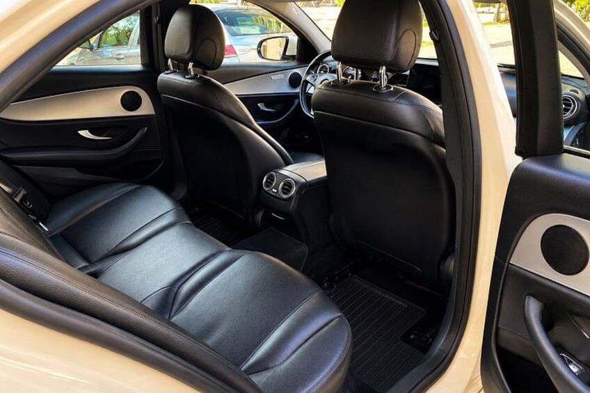 The interior of a car with black leather seats, a steering wheel, and a dashboard. 2