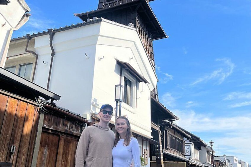 A building with a white facade and wooden elements, a clear blue sky, and a wooden fence. 2