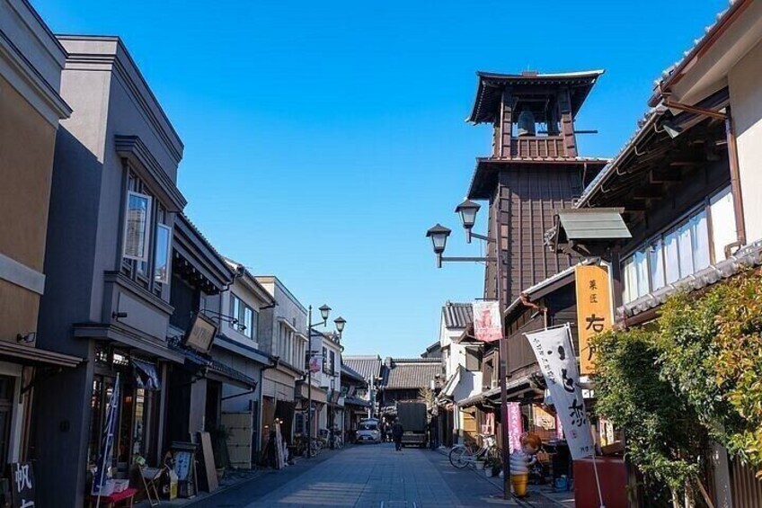 A street lined with traditional buildings, a bell tower, and various signs. 4