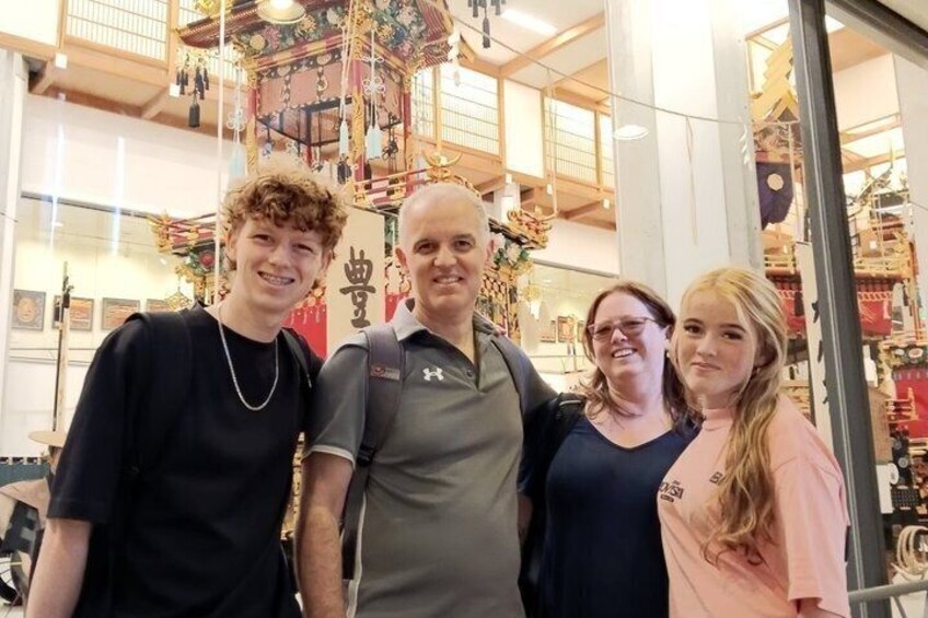 A group of people in a shopping mall with a traditional Asian architectural structure in the background. 3