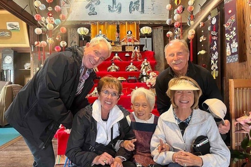 A group of people in a shop with traditional decorations and red furniture. 3