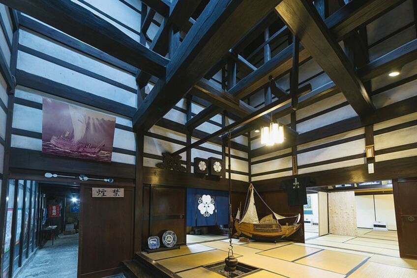 A traditional Japanese interior with tatami flooring, a hanging lantern, and a wooden boat model. 5