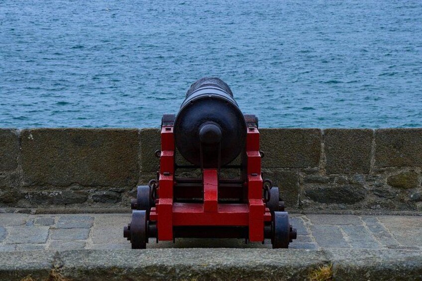 A cannon on a stone platform by the water. 4