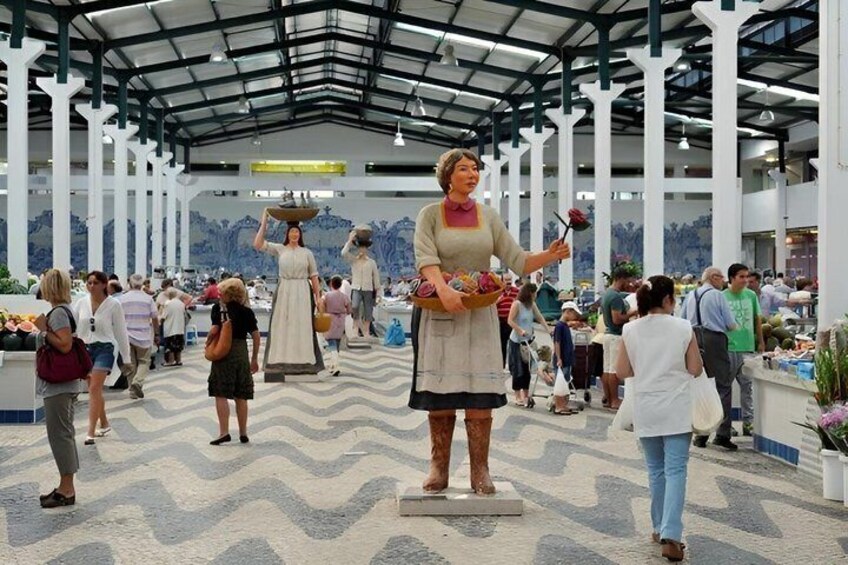 A covered market with white pillars and a patterned floor. 1