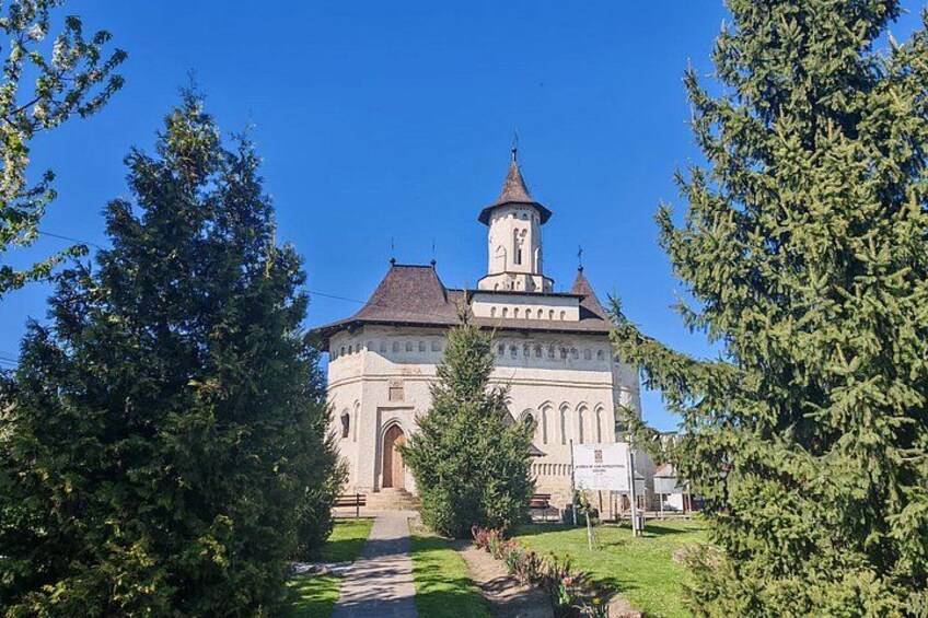 A church with a bell tower, surrounded by trees and a pathway. 2