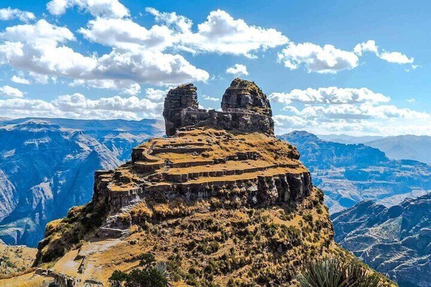 A mountainous landscape with a prominent rock formation and a winding path. 4