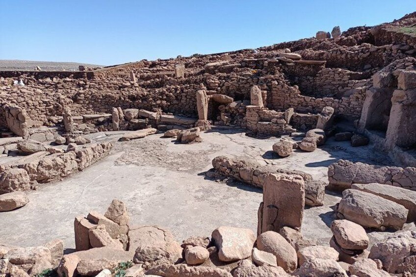 Ancient ruins with stone structures and a central open area. 4