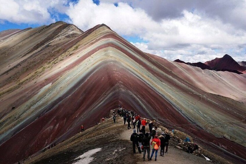 A group of people hiking on a colorful mountain trail. 3