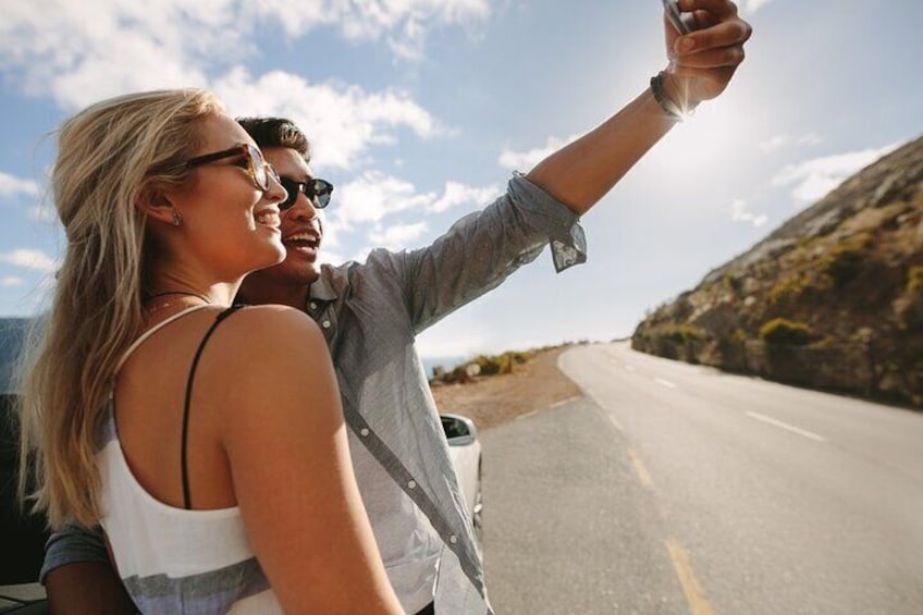 A couple taking a selfie on a road with a clear sky. 3