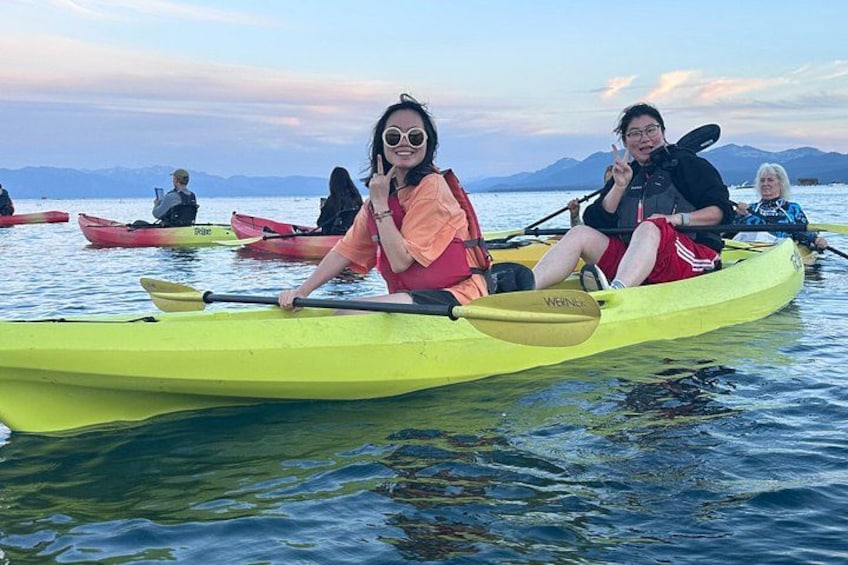 People kayaking on a calm lake with mountains in the background. 4