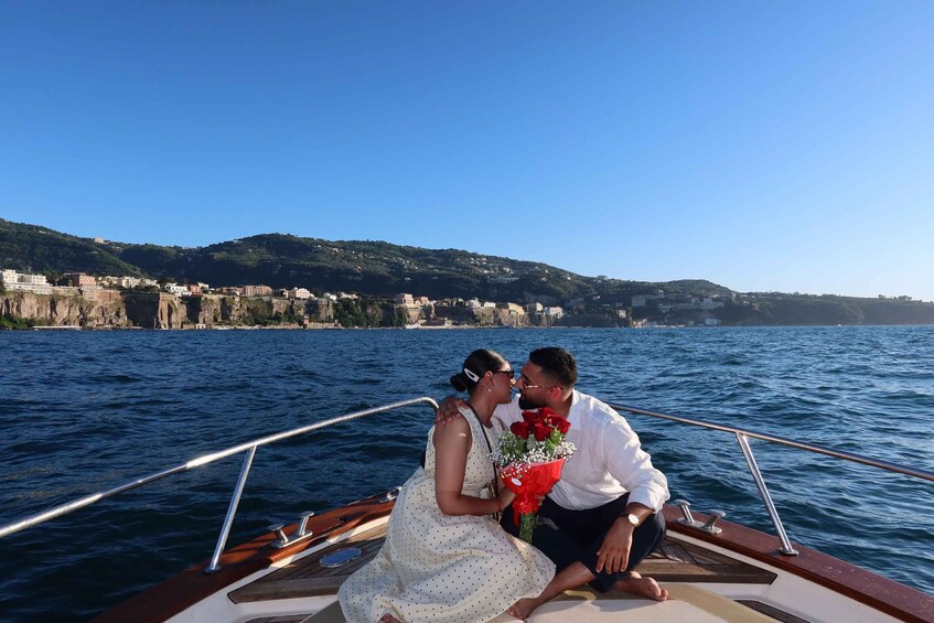 A couple on a boat with a coastal cityscape in the background. 5