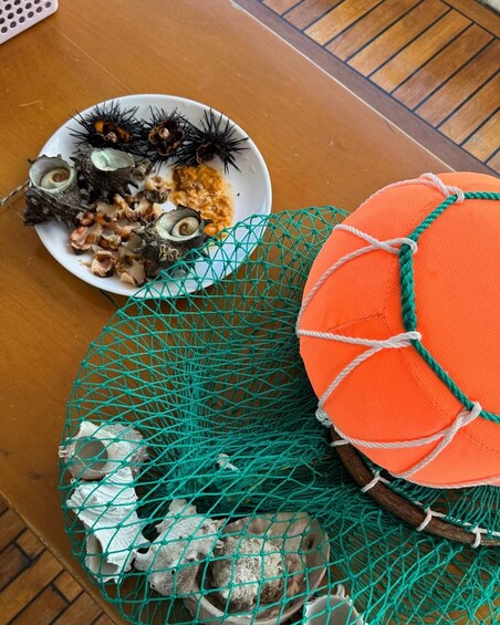 Ein Tisch mit Meeresessern, ein Netz mit Muscheln und ein Basketball. 2
