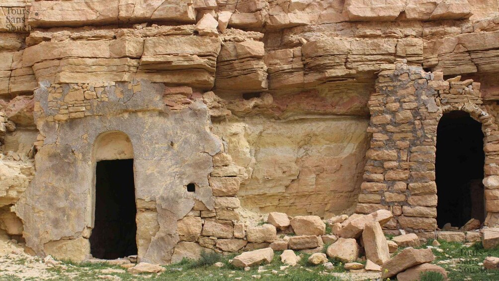 Ancient ruins with two arched doorways and a stone wall. 5