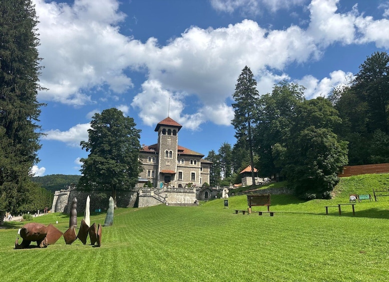 A historic building with a tower, surrounded by lush greenery and a clear sky. 5