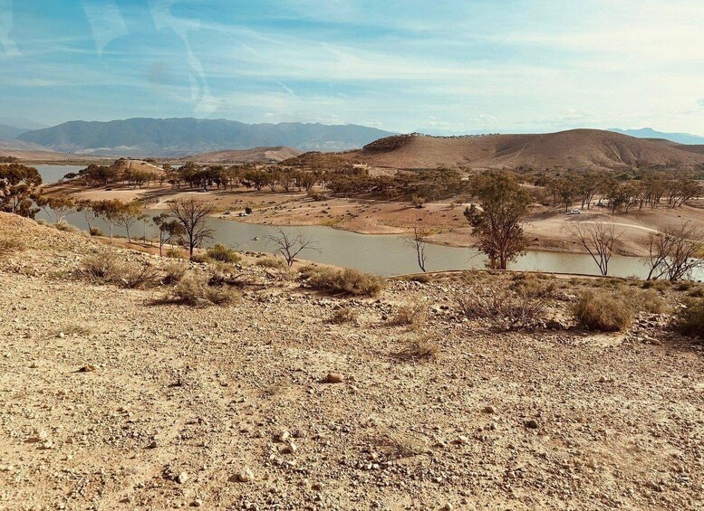 A dry, rocky landscape with sparse vegetation and a winding river. 5