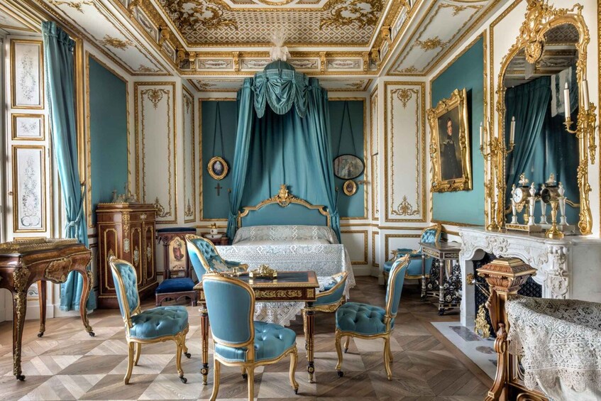 A luxurious bedroom with a large bed, ornate furniture, and elaborate decorations. 3
