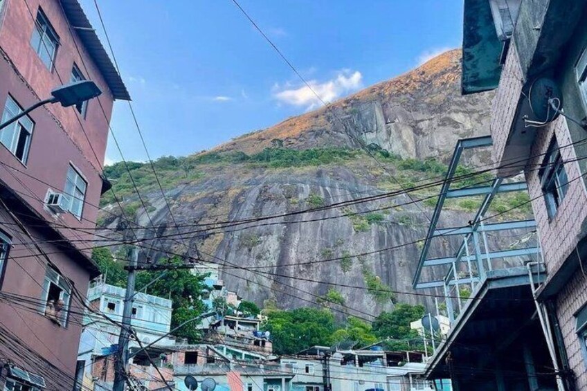 A city street with buildings, power lines, and a mountain in the background. 2