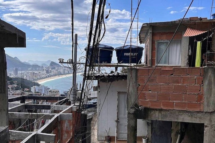 A construction site with exposed wires and unfinished buildings, overlooking a beach and cityscape. 5